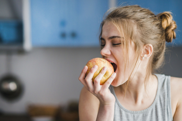 Chica comiendo manzana por uno de los consejos de dentistas