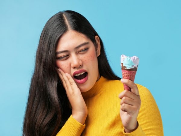 Mujer comiendo un helado, l que según los consejos de dentistas genera sensibilidad dental