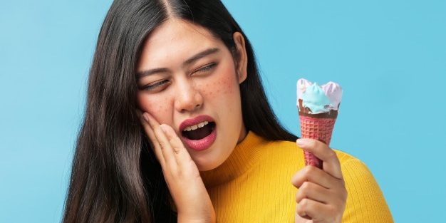 Mujer comiendo un helado, l que según los consejos de dentistas genera sensibilidad dental